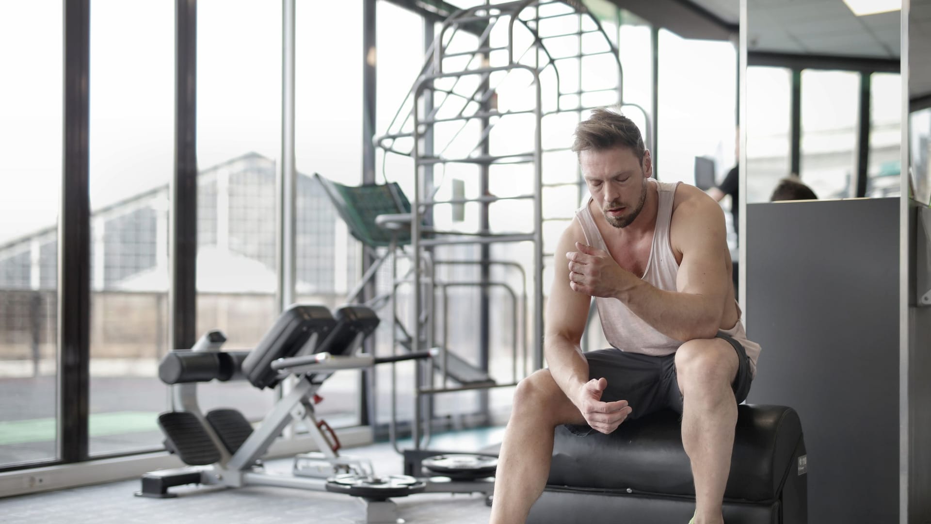 Muscular male athlete resting after a weightlifting workout