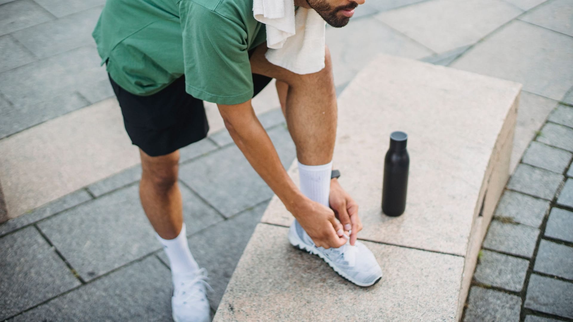 Man tying his sneakers before an outdoor workout